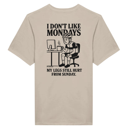 T-Shirt Rückseite: Müder Radfahrer mit Kaffee am Schreibtisch – Text: I Don’t Like Mondays – My Legs Still Hurt from Sunday